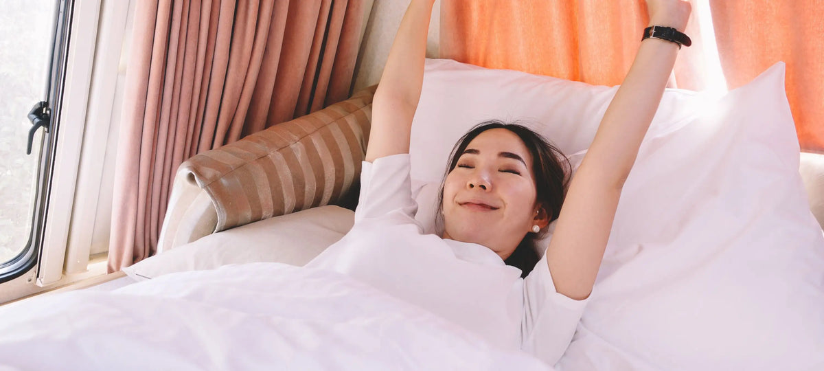 Eine Frau sieht ausgeschlafen und erholt aus im Bett.