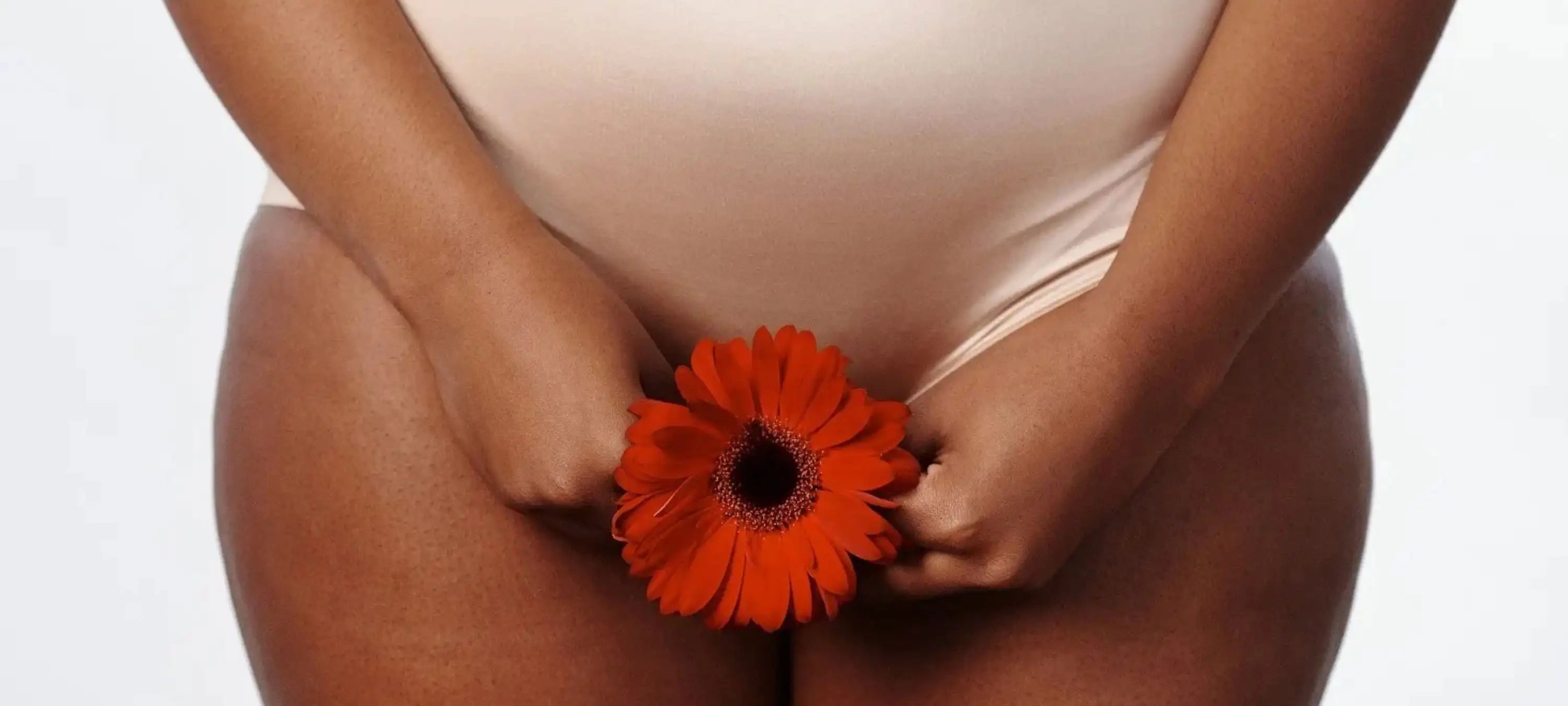 Unterkörper einer Frau, die eine Blume hält.