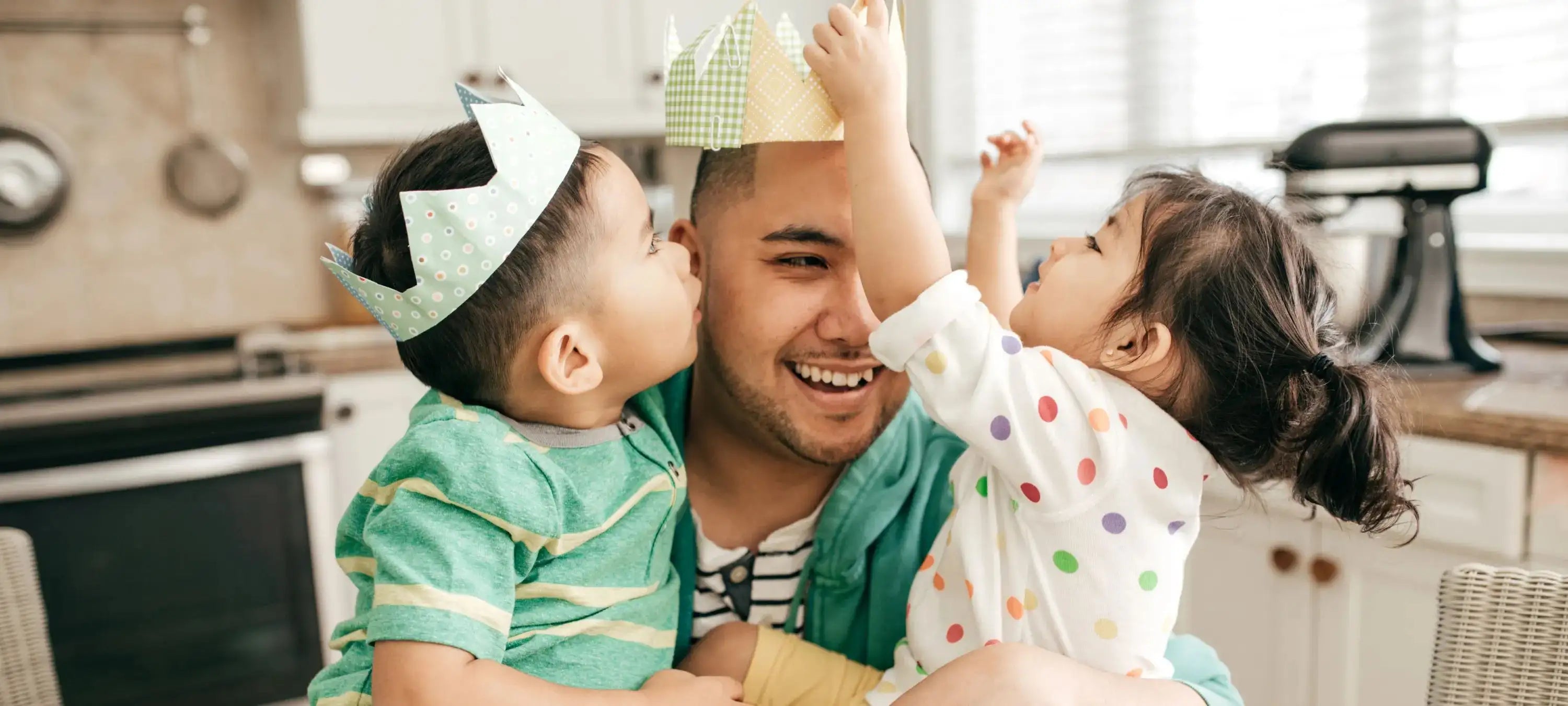 Ein Vater tollt mit seiner Tochter und seinem Sohn.