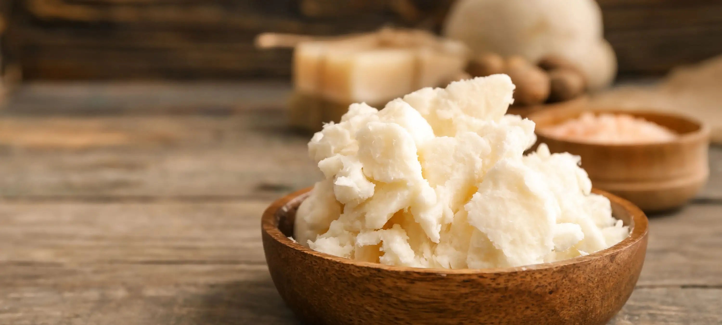 Sheabutter in einer Holzschale. Sie pflegt die Haut natürlich.