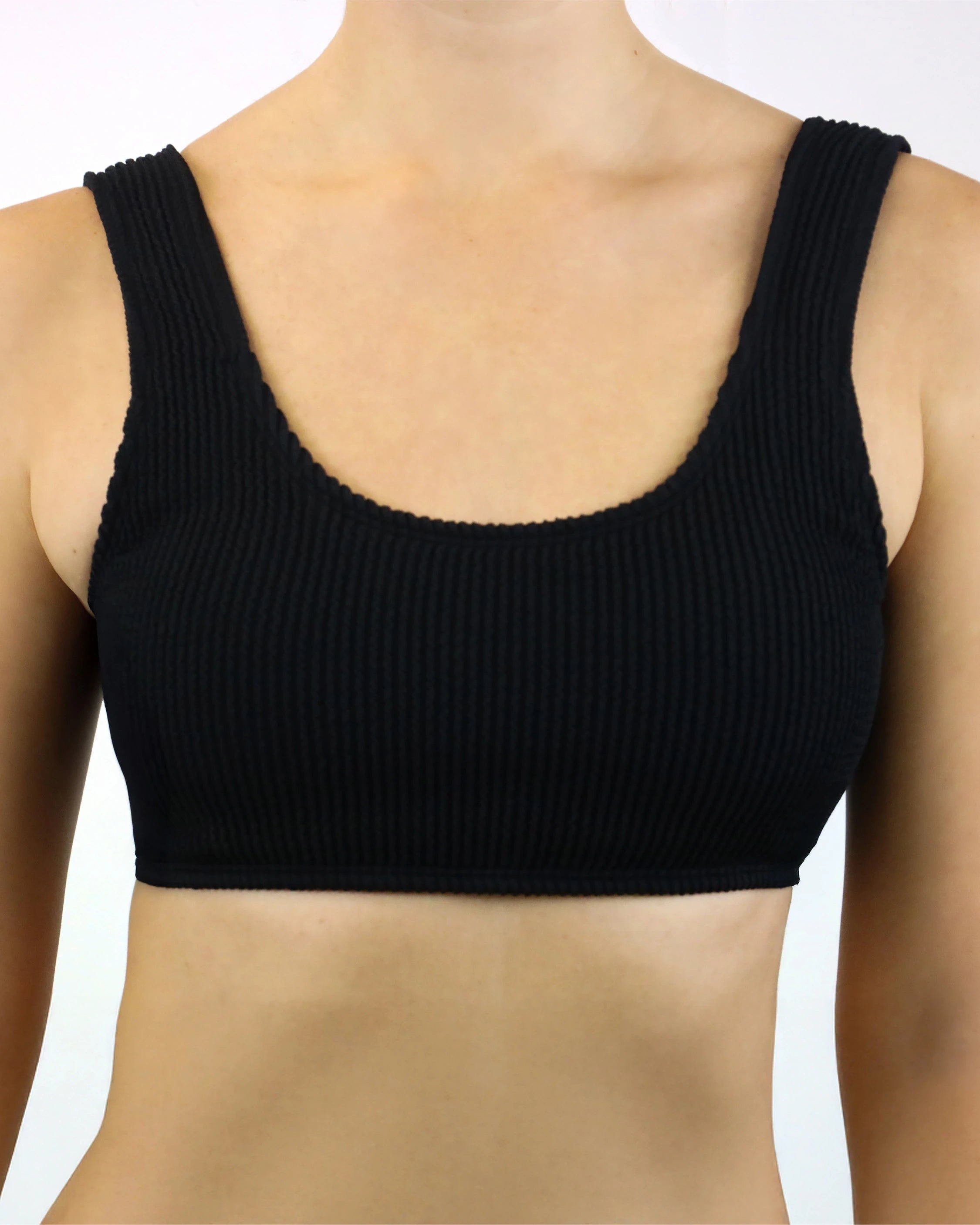 Schwarzes geripptes Bikini-Oberteil mit breiten Trägern, getragen von einem Model.