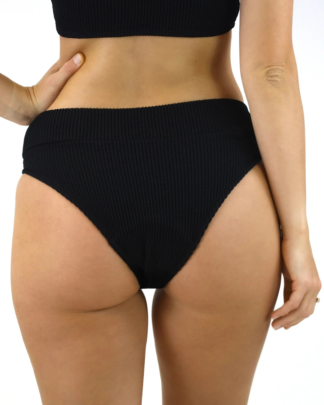 Schwarze Bikinihose mit hohem Bund und gerippter Struktur, von hinten gezeigt. Bequeme Passform, ideal für Strand, Pool und Sommermode.