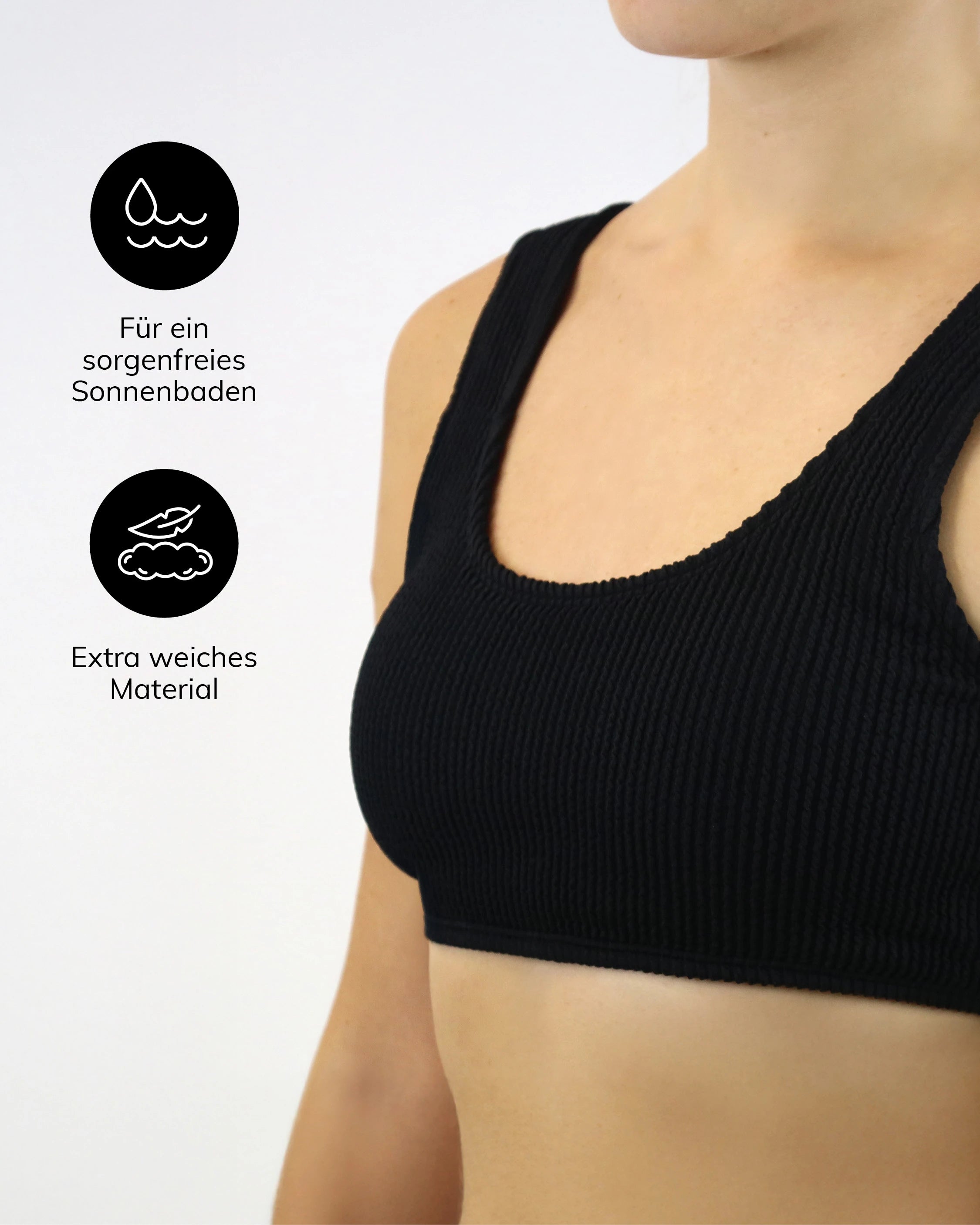 Schwarzes geripptes Bikini-Oberteil mit breiten Trägern, weichem Material und wasserfreundlicher Eigenschaft, präsentiert an einem Model.