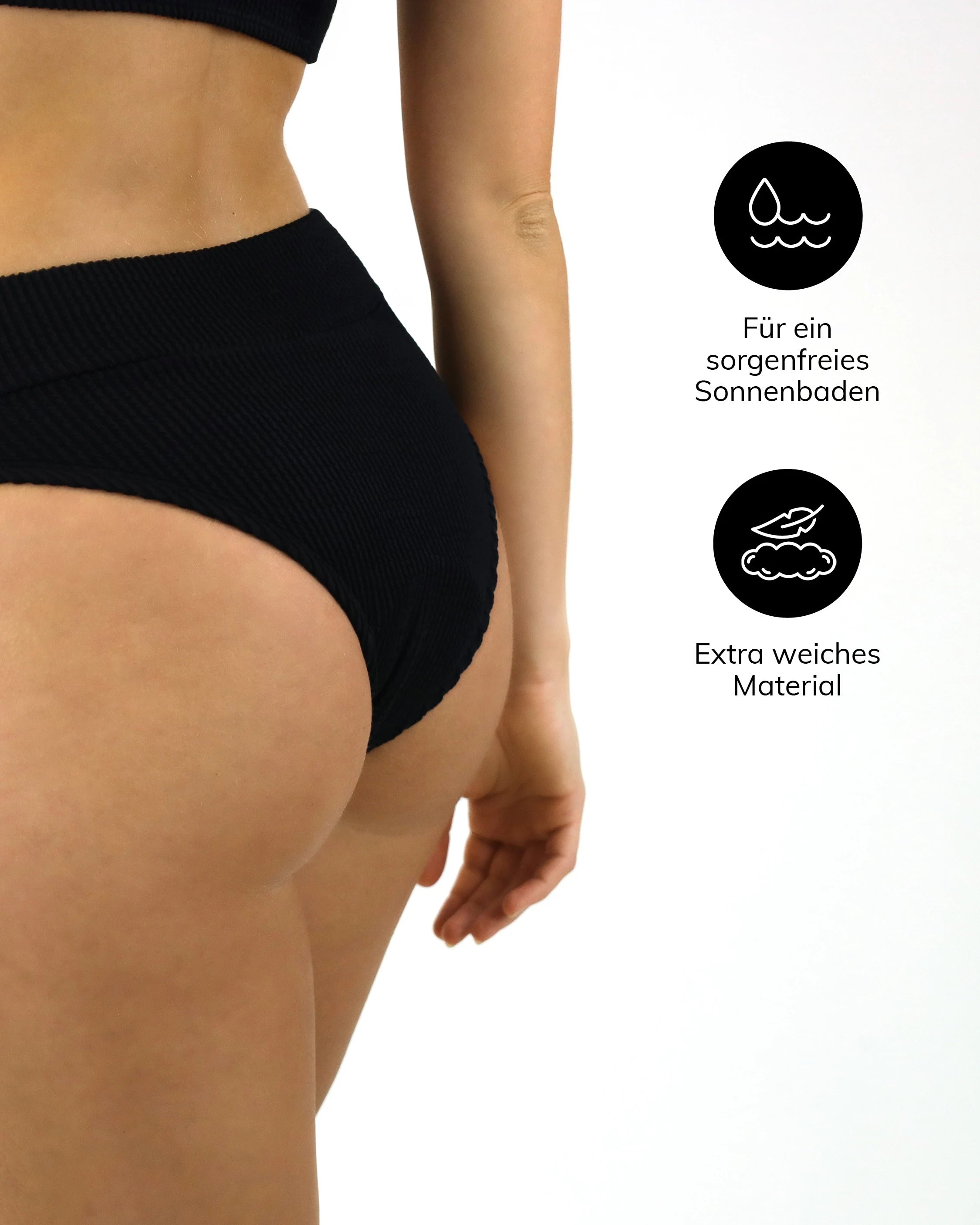 Schwarze Bikinihose mit hohem Bund und gerippter Struktur, von hinten seitlich gezeigt. Extra weiches Material für maximalen Komfort am Strand.