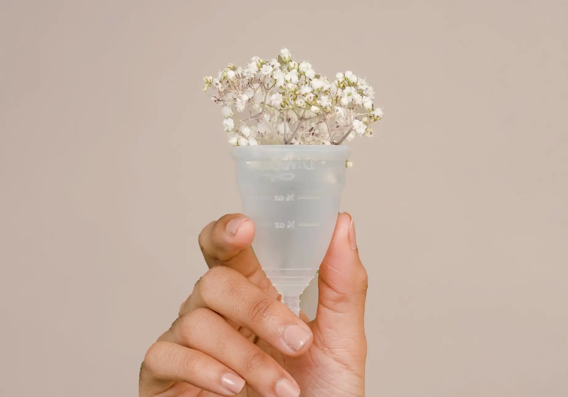Eine Menstruationstasse mit Baumwolle drin. Periodenprodukte verursachen viel Müll. MYLILY produziert nachhaltige Produkte für die Bedürfnisse von Frauen*.
