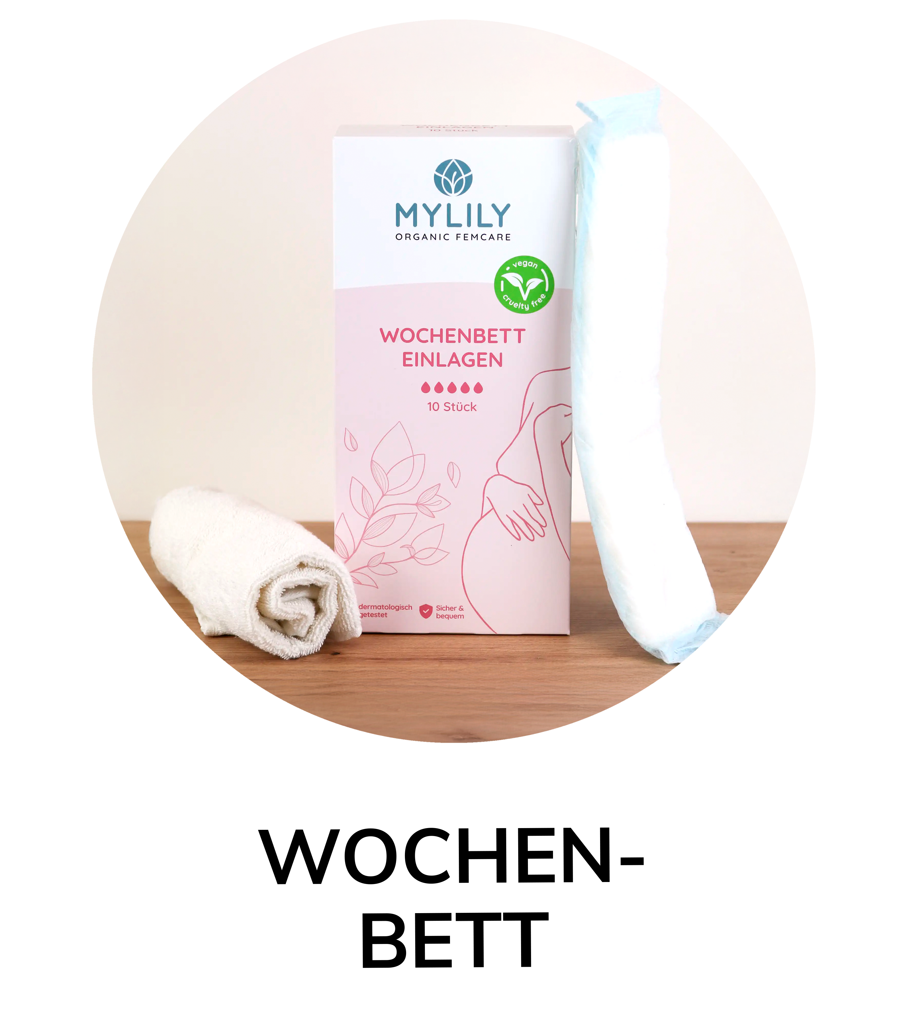 MYLILY Wochenbett-Einlagen in rosa-weißer Verpackung, daneben eine gefaltete Stoffwindel und eine Einlage auf Holzfläche.