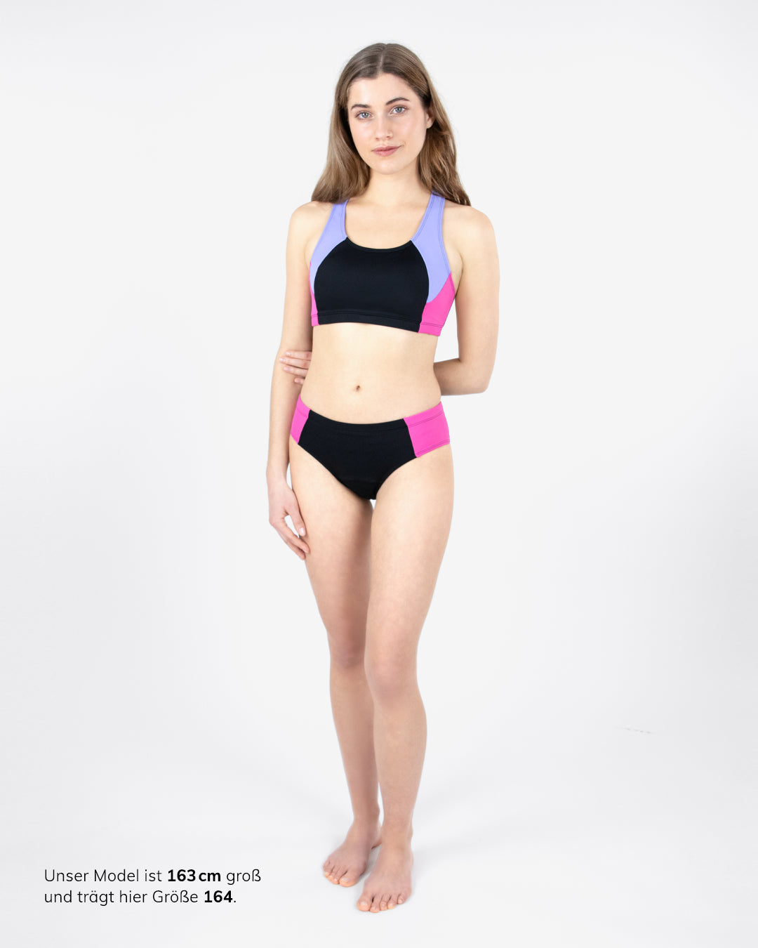 MYLILY Teens Sportiv-Bikini Set schwarz/lila/pink: Racerback-Bustier mit passendem Colorblock-Bikinioberteil und Bikinihose – sportliche Periodenbademode für Mädchen, Modellgröße 163 cm, Größe 164, Ganzkörperansicht