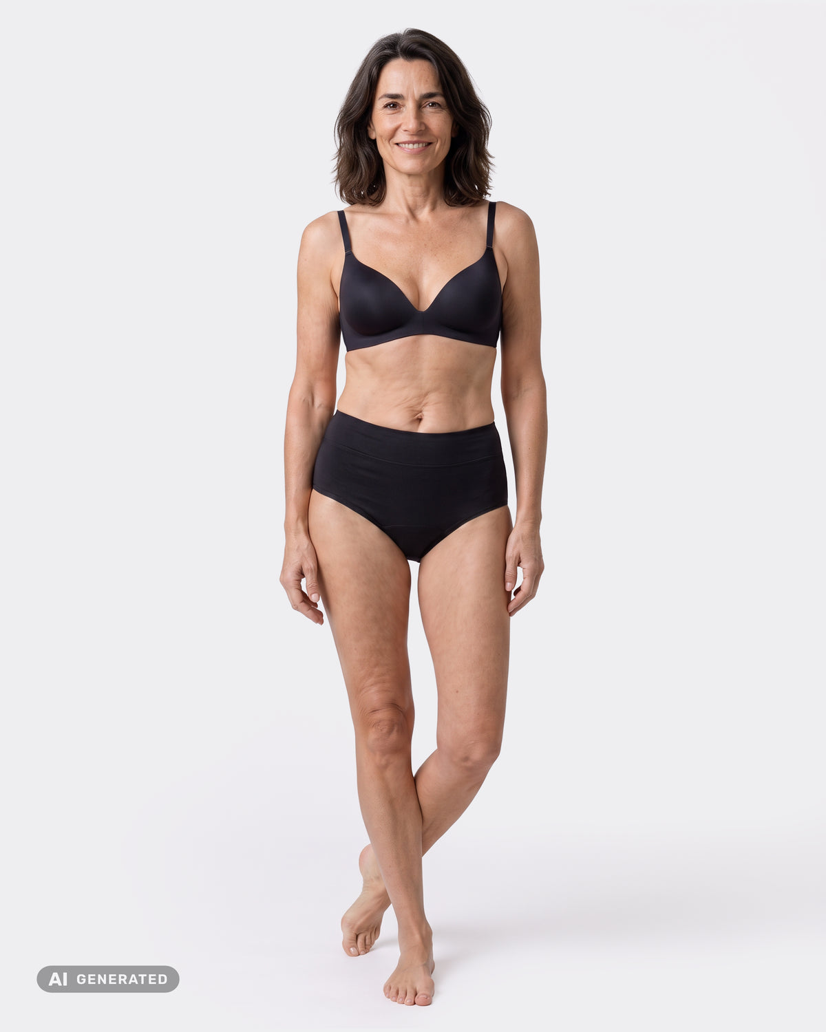 Lächelnde Frau steht in schwarzem High-Waist-Periodenslip und schwarzem BH barfuß mit überkreuzten Beinen, Ganzkörperansicht.