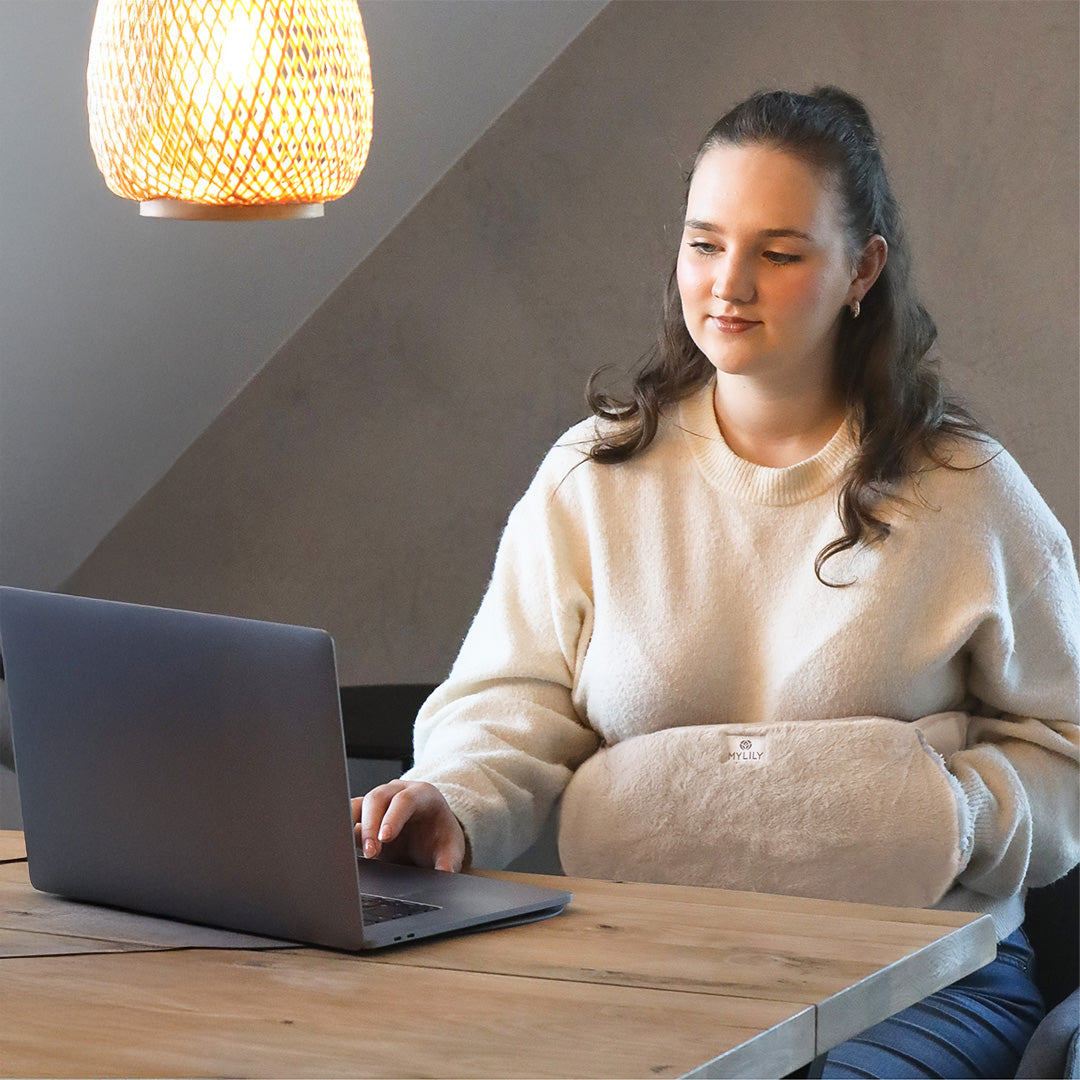 Der MYLILY Wärmegürtel wärmt den Unterleib einer Frau bei der Arbeit am Laptop