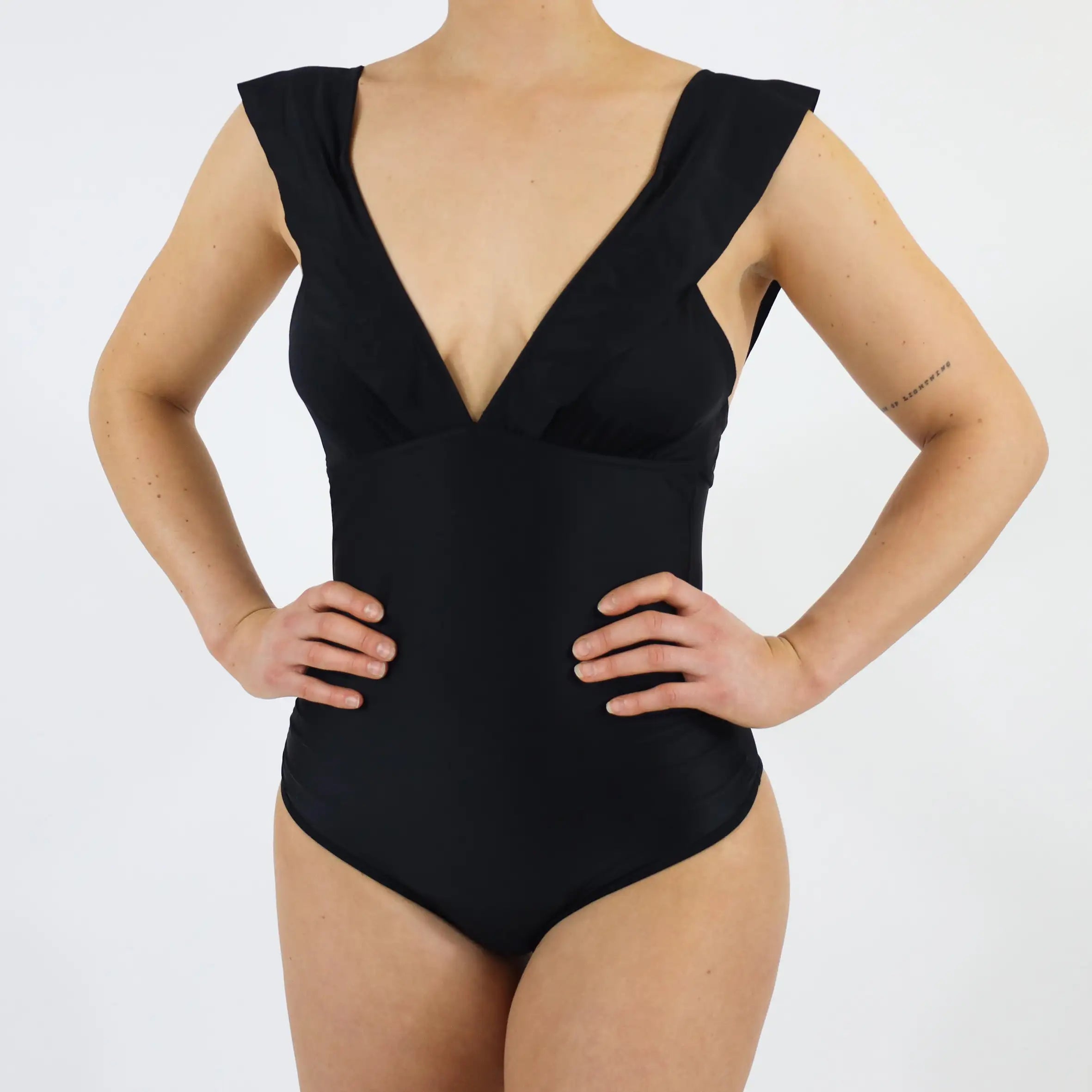 Frau trägt MYLILY Perioden Bademode für Menstruierende. Mit schönen Rüschen und V Ausschnitt.