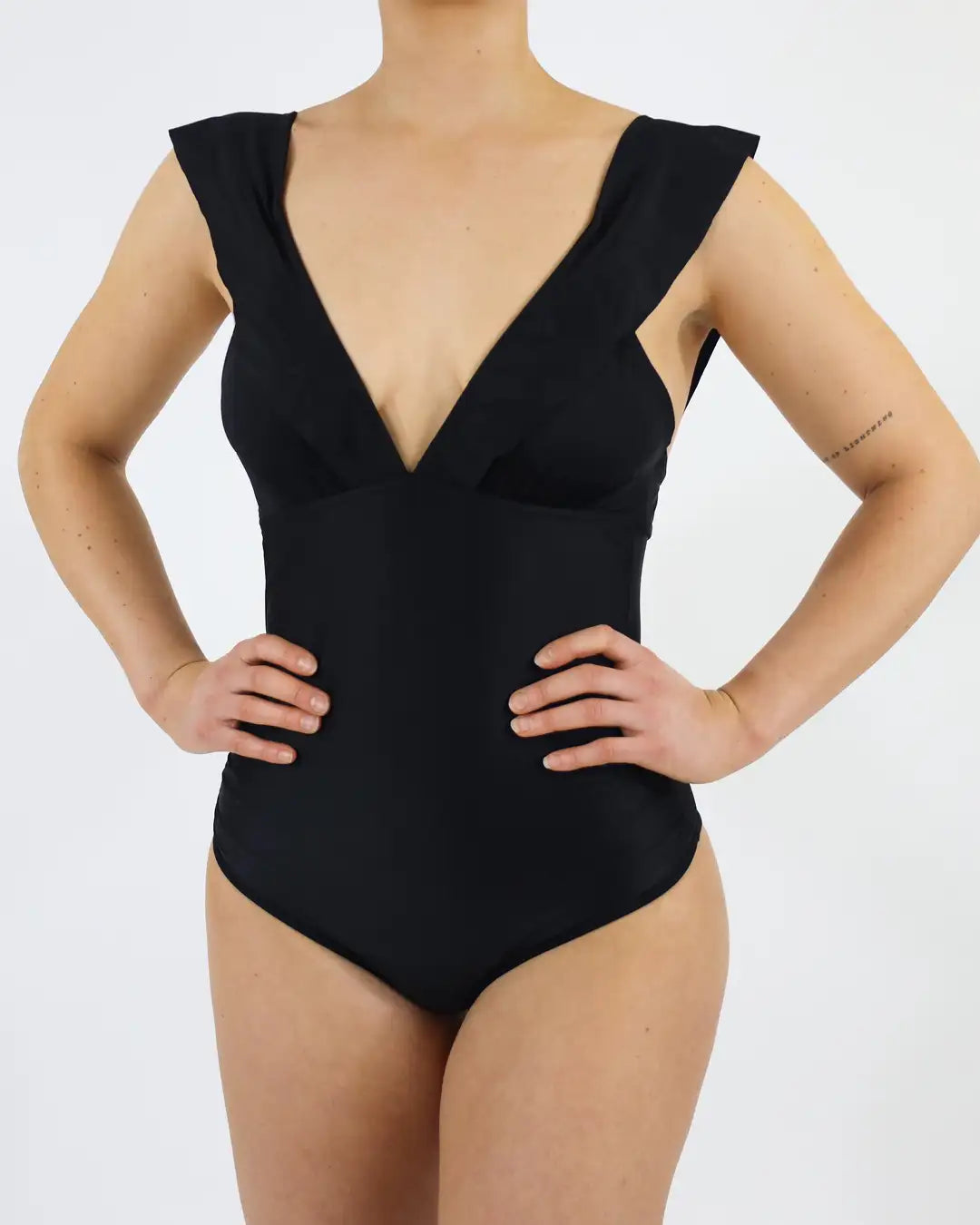 Frau trägt MYLILY Perioden Bademode für Menstruierende. Mit schönen Rüschen und V Ausschnitt.