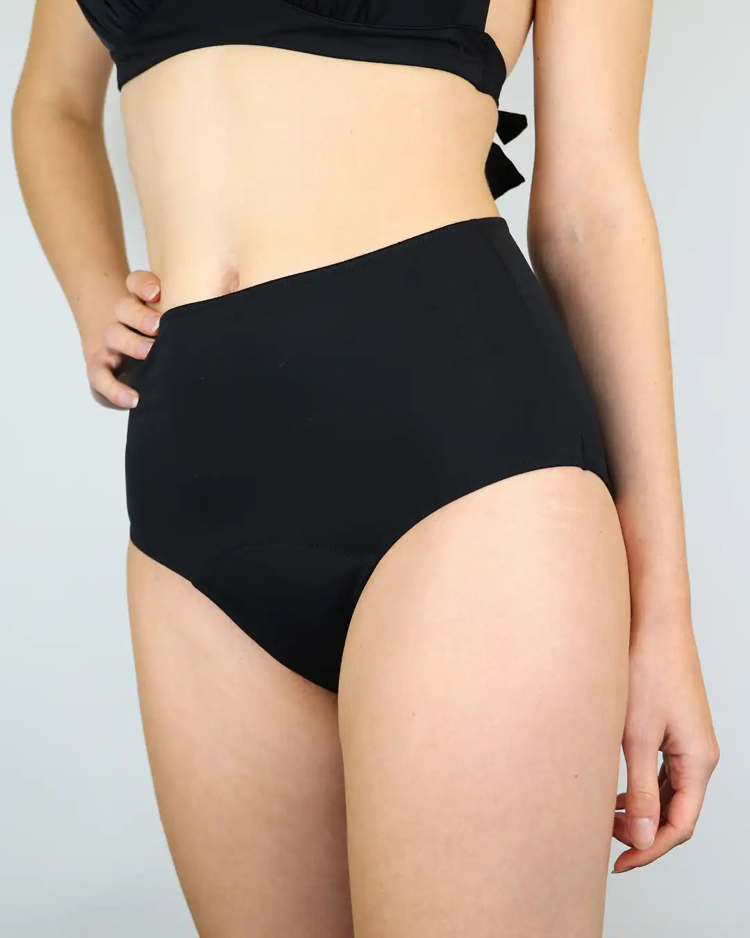 Frau trägt High Waist Bikinihose Menstruation: auslaufsicher, geeignet für heiße Sommertage und leichte Tage.