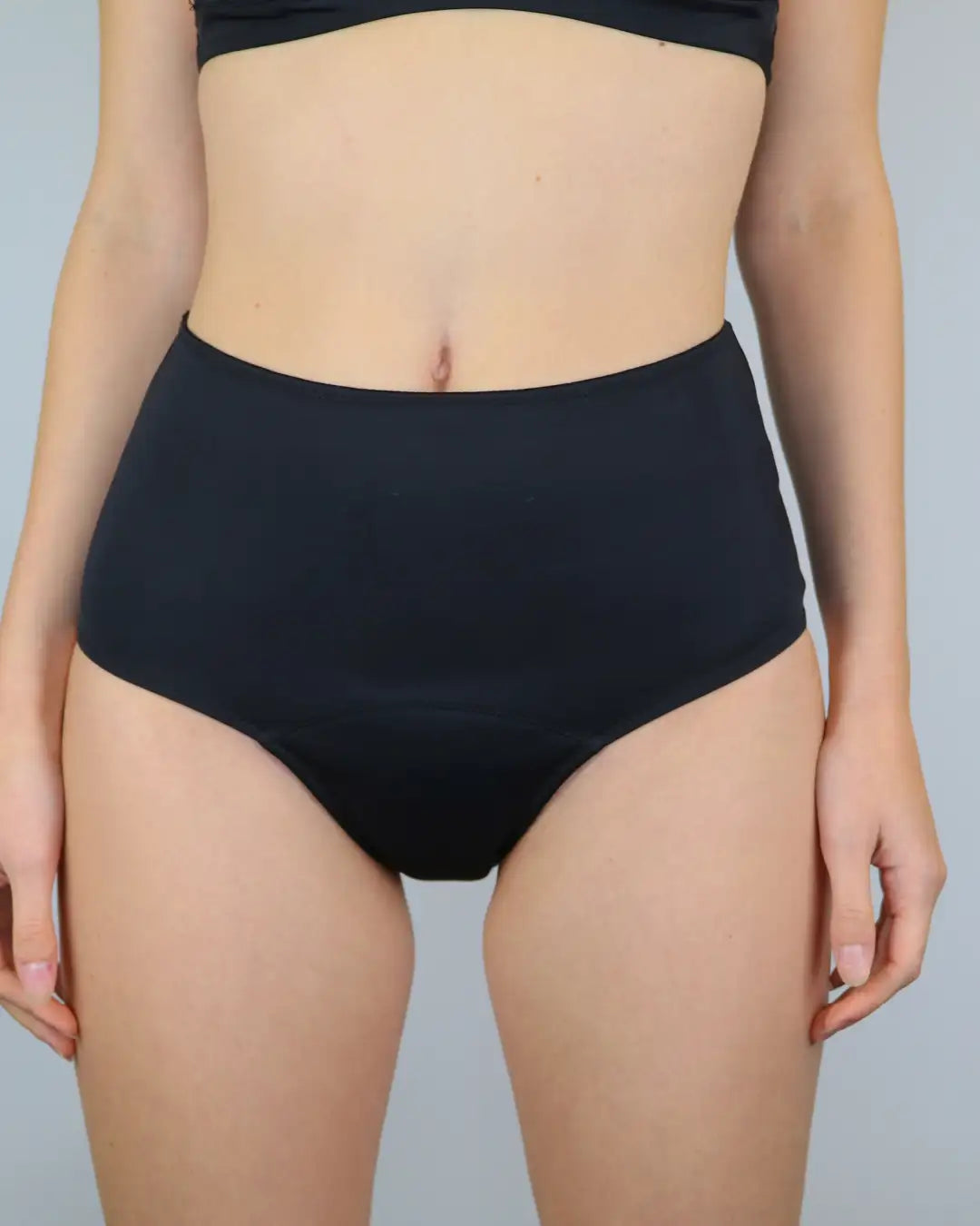 Frau trägt Bikinihose für die Menstruation für leichte Tage. Der Perioden Bikini High Waist ist Biozid frei und nachhaltig.
