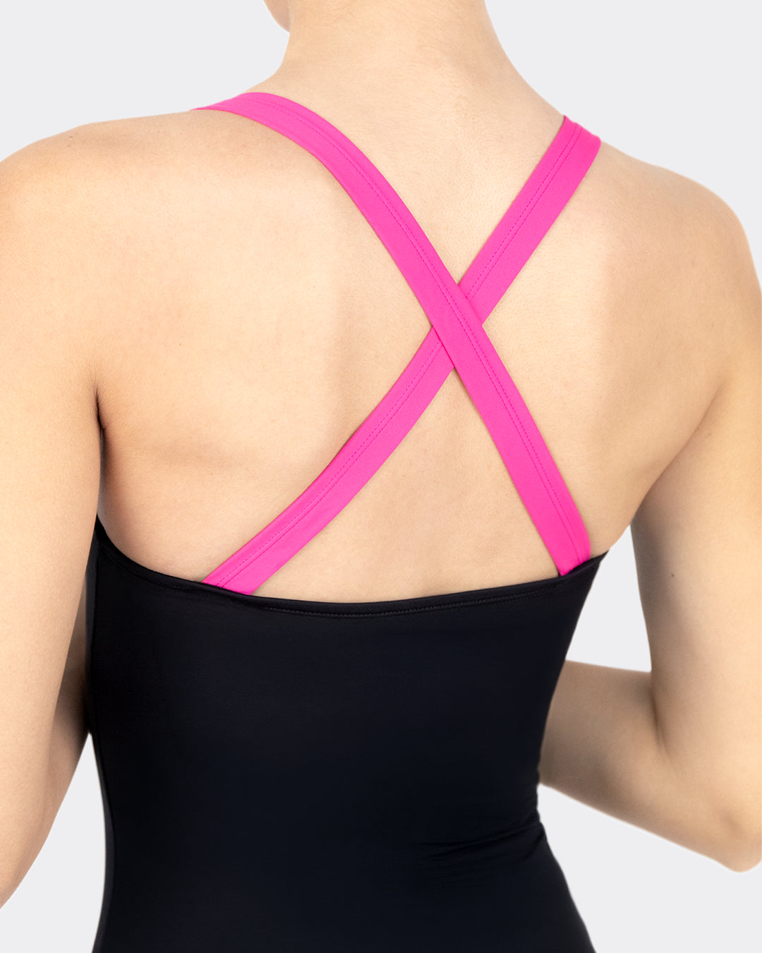Nahaufnahme Rückendetail MYLILY Perioden-Badeanzug: breite pinkfarbene Kreuzträger in X-Form auf schwarzem Stoff – charakteristisches Crossed-Back-Design des sportlichen Perioden-Einteilers
