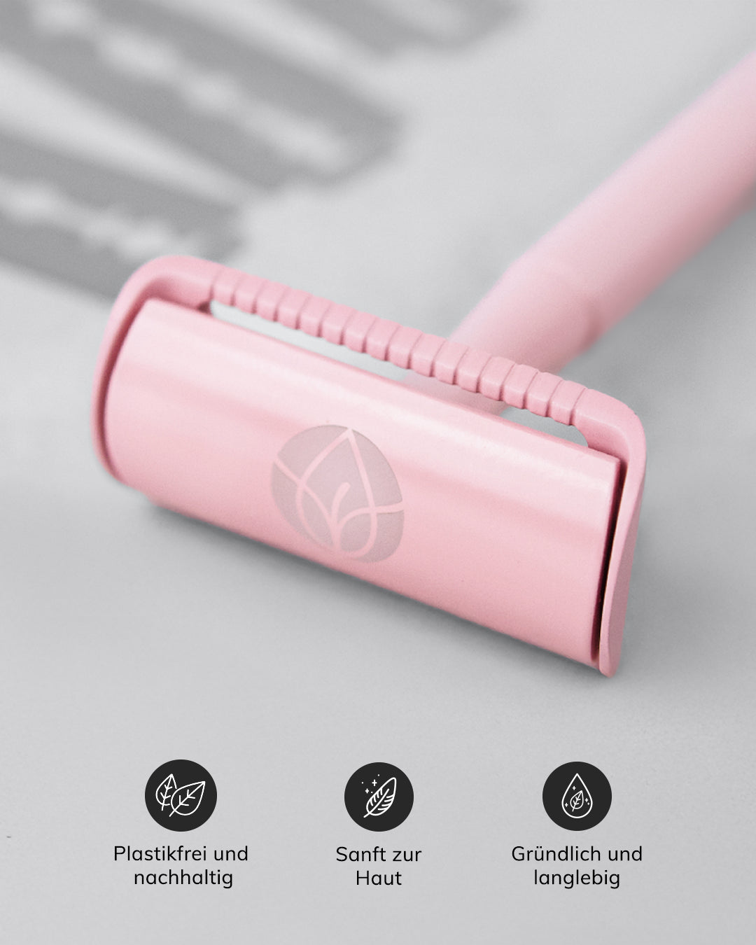 Rosa Rasierer mit Blatt-Symbol auf dem Kopf, daneben Piktogramme mit den Texten: 'Plastikfrei und nachhaltig', 'Sanft zur Haut' und 'Gründlich und langlebig'.