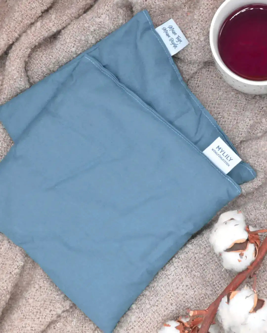 Nachhaltiges Wärmkissen für Bauchschmerzen und Krämpfe. Körnerkissen für die Periode. Wärmkissen auf Decke mit Tee und Bio Baumwolle