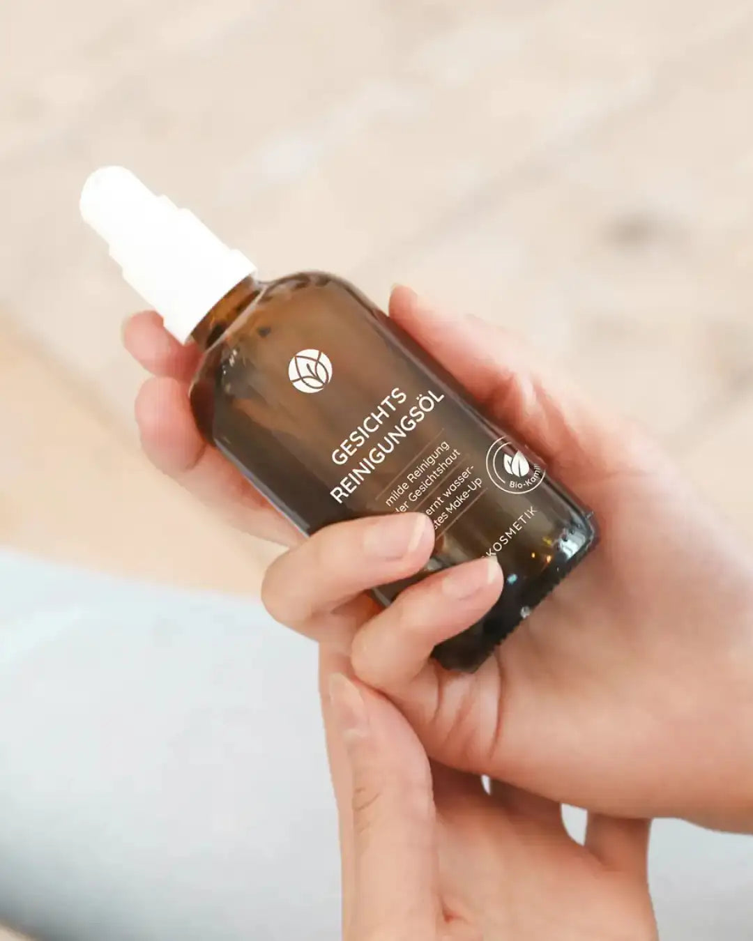 Naturkosmetik Produkt in Hand liegend: Reinigungsöl Gesicht für alle Hauttypen. Mit Jojobaöl und Mandelöl