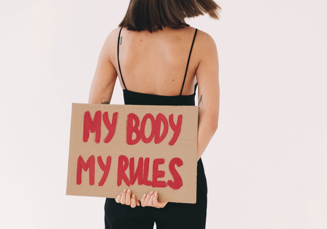 Frau mit Demoschild: my body my rules. MYLILY setzt sich für Empowerment von Frauen ein. Sei wie du willst.