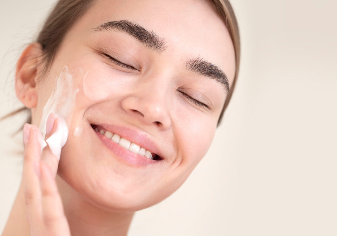 Frau verteilt Creme auf ihrem Gesicht. Schonende Hautpflege und Intimpflege mit Naturkosmetik von MYLILY