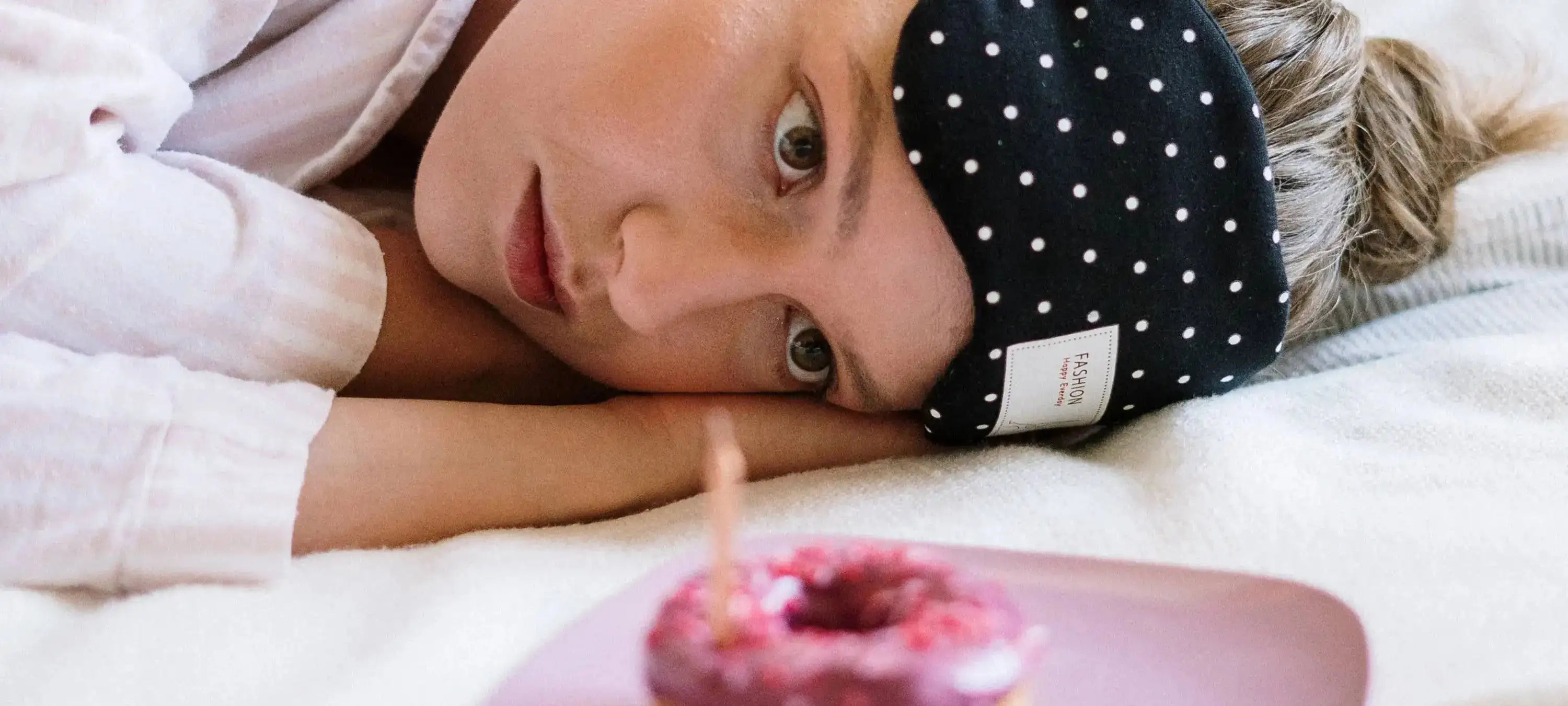 Ein Mädchen guckt sehnsüchtig auf einen Donut, wobei der MYLILY Workshop zur zyklischen Ernährung dabei hilft, solche Heißhunger Attacken vorzubeugen.