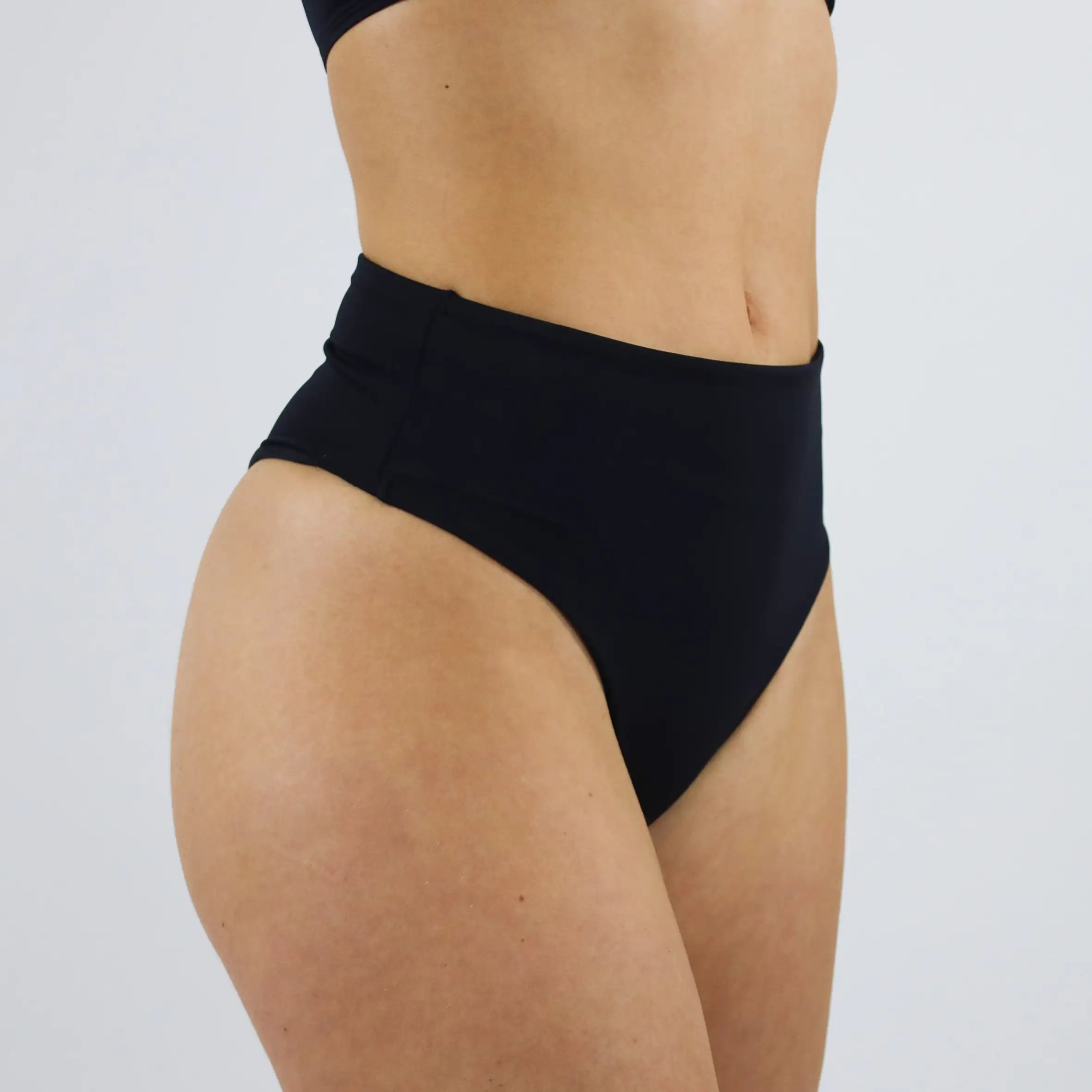 MYLILY Brazilian Bikini Hose schräg von der Seite. Zeitlose Bademode. Vegan und nachhaltig MYLILY organic femcare aus Bio-Baumwolle. Der perfekte Bikini für alle Größen. #farbe_schwarz