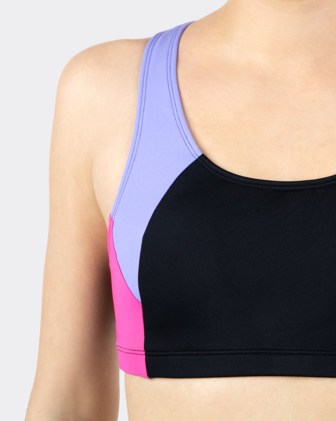 Nahaufnahme MYLILY Teens Sportiv-Bustier schwarz-lila-pink mit Racerback-Trägern in Lila und pinkfarbenem Seitenpanel – sportliches Colorblock-Bikinioberteil für Mädchen, Detailansicht von vorne