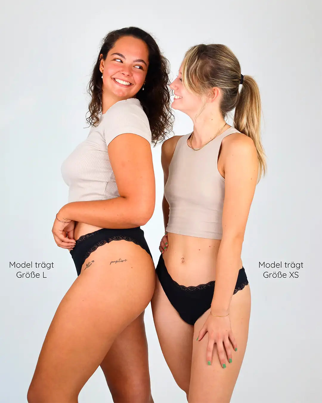 Zwei Models zeigen den eleganten Spitzenbund der Menstruationsunterwäsche. Sexy und funktional zugleich.