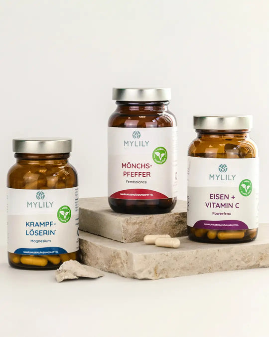 3er Pack: vegane Nährstoffe mit Magnesium, Eisen und Vitamin C in umweltfreundlicher Glasflasche, die Supplements stehen auf einer Steinplatte.