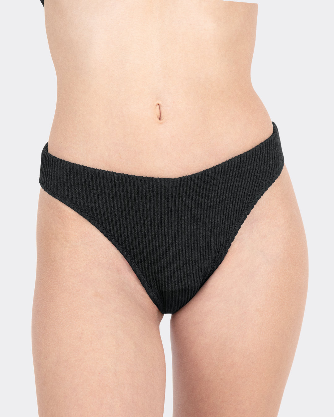 Nahaufnahme MYLILY Crinkle V-Shape-Periodenbikinihose schwarz mit charakteristischer Ripp-Textur und tiefem V-förmigem Beinausschnitt – modische Periodenbademode, Frontansicht freigestellt