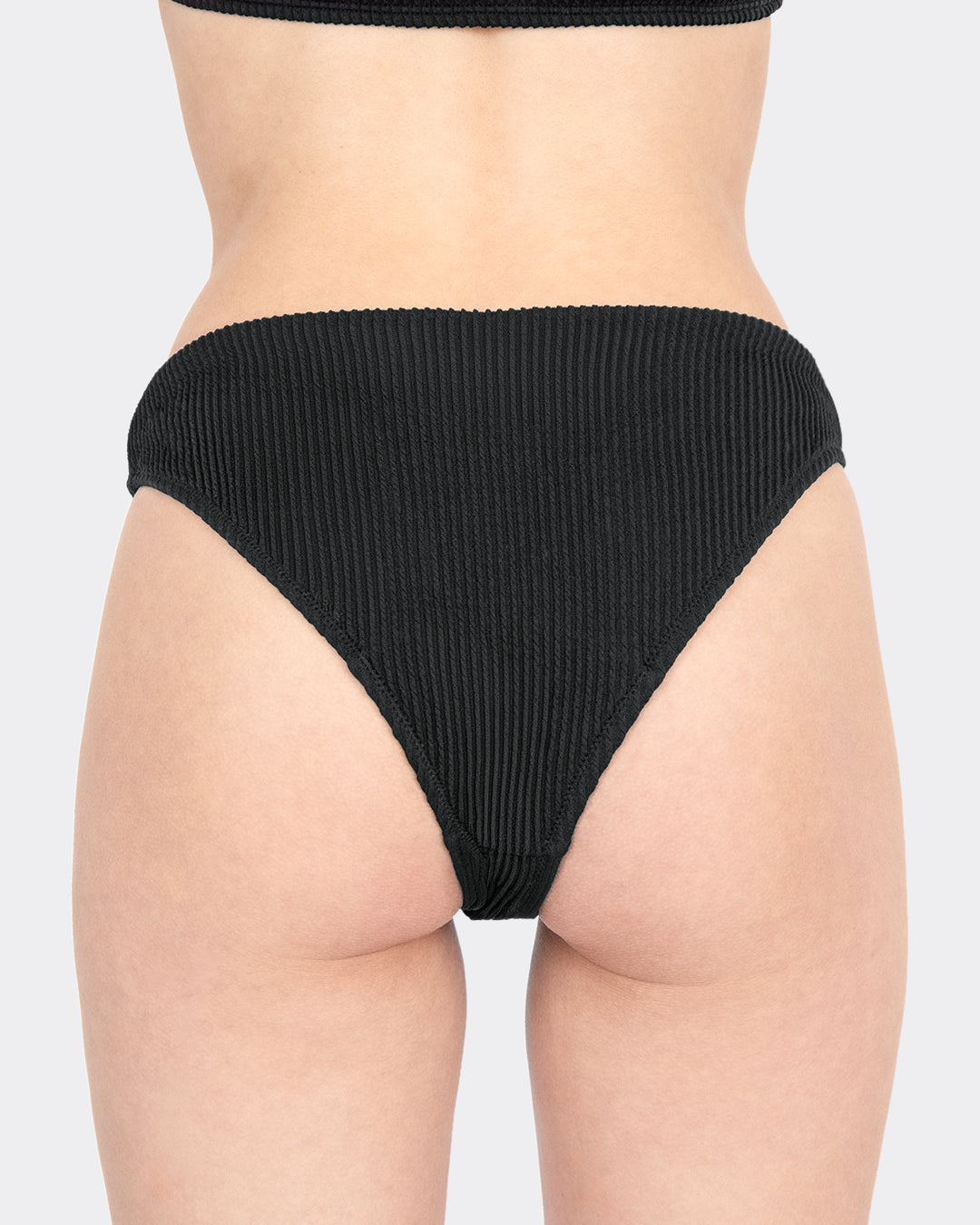 Rückansicht MYLILY Crinkle V-Shape-Periodenbikinihose schwarz mit breitem Bund und V-förmigem Schnitt – Periodenbademode mit zuverlässigem Auslaufschutz, freigestellt auf hellem Hintergrund