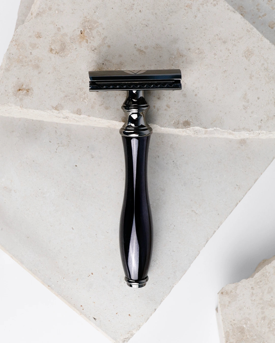 Schwarzer Rasierhobel auf Steinplatte. Kann für Achseln, Arme, Beine und zur Intimrasur verwendet werden. 