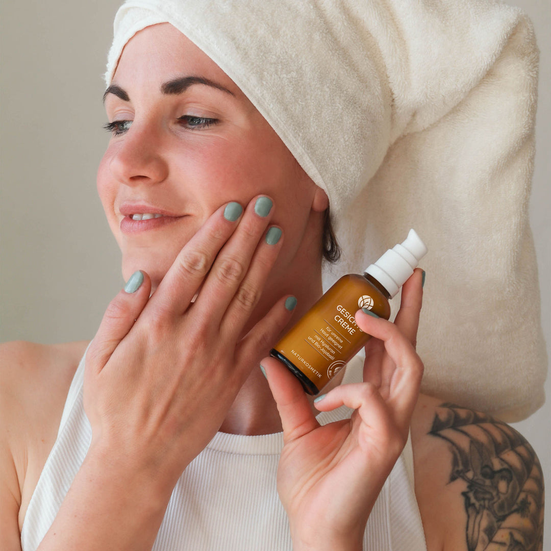 Frau cremt ihr Gesicht mit der MYLILY Gesichtscreme mit Hyaluronsäure für unreine Haut ein.