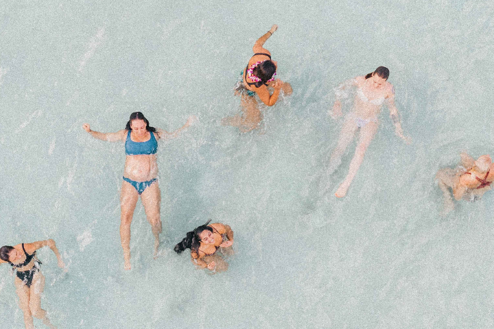 Mehrere Frauen in Bikinis entspannen in Wasser