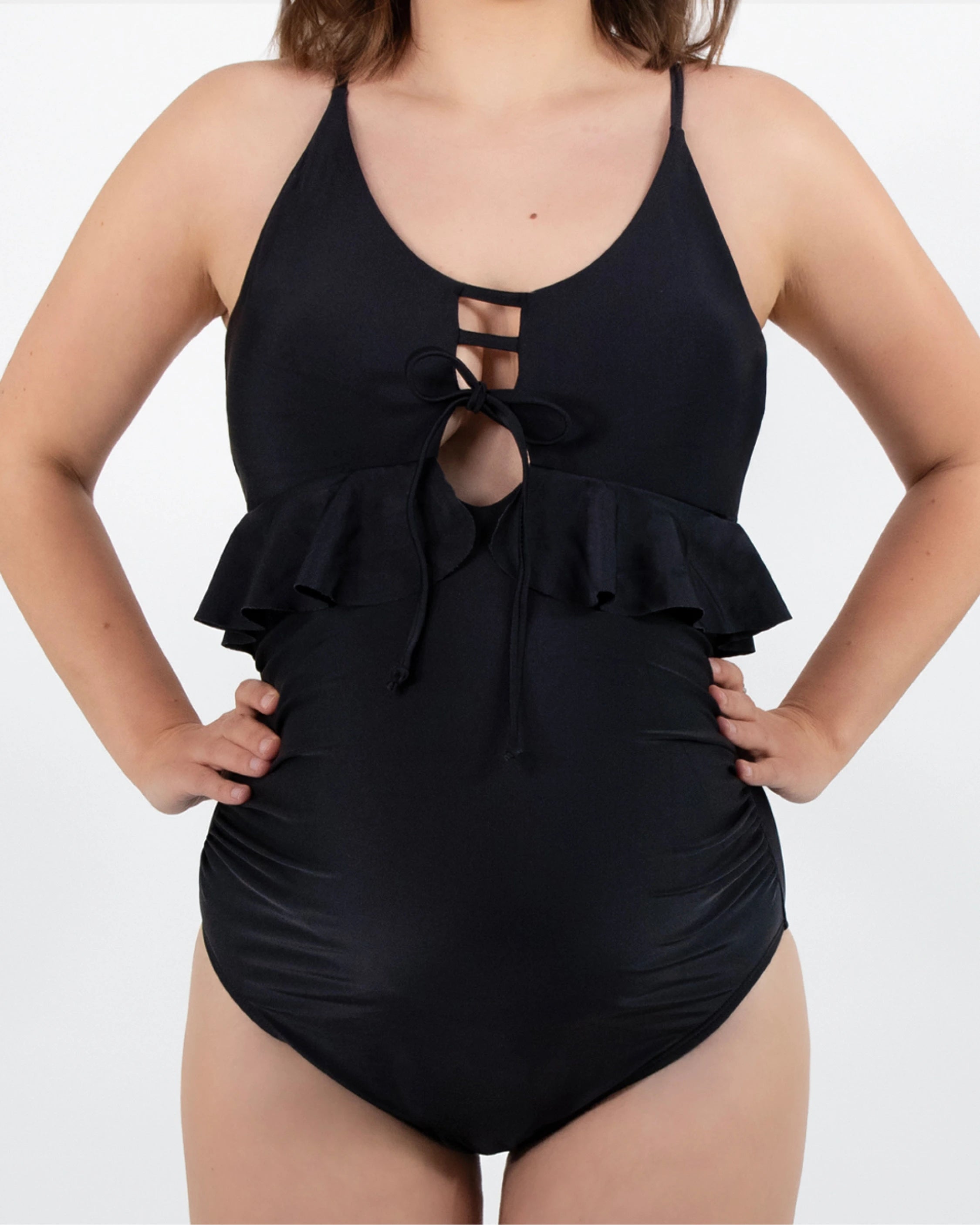 Model in dem gerüschten Umstandsbadeanzug in schwarz von vorne. 